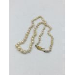 A cultured row of graduated pearls on 18ct yellow gold diamond set clasp