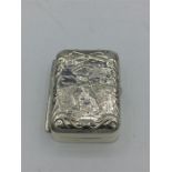 A silver golf tee box with embossed image