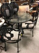 A cast iron, glass topped garden table
