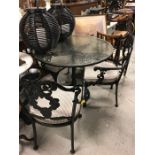 A cast iron, glass topped garden table