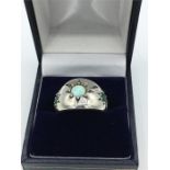 A silver emerald and opal ring