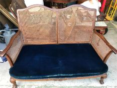 A Two seater cane backed sofa and matching chair with blue seats
