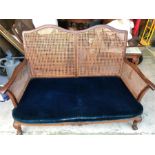 A Two seater cane backed sofa and matching chair with blue seats