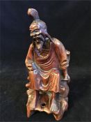 A carved redwood seated Chinese immortal (19cm)