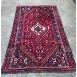 An Iranian hand woven red ground rug