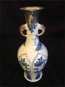 A Kangxi period Chinese blue and white vase with silver top.