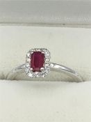 An 18ct white gold ruby and diamond cluster ring of 50 points approx