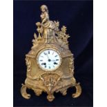 A gilt clock with figure with bird.