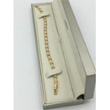 A yellow gold diamond set line bracelet set with 23 diamonds of 1.2ct's approx