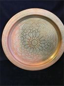 A Persian copper tea tray with ornate detail.