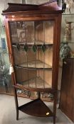 A three shelf display cabinet with stained glass front