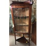 A three shelf display cabinet with stained glass front