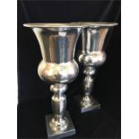 A pair of tall silver coloured thistle shaped vases