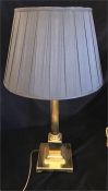 A brass column lamp base with black shade.