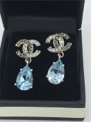 A pair of silver CZ and Blue Topaz drop earrings in a designer style
