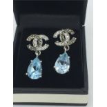 A pair of silver CZ and Blue Topaz drop earrings in a designer style