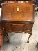 A small mahogany bureau with shell detail on legs