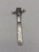 A silver owl shaped Babies rattle with mother of pearl handle