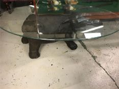 A glass coffee table with an elephant figure base