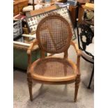 An Ornate carved French cane backed and seated carver chair