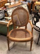 An Ornate carved French cane backed and seated carver chair