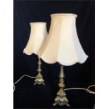 A pair of brass table lamps with Ivory shades