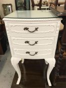 A white three drawer bedside cabinet