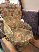A Low button back nursing chair with a heavy fabric gold cover
