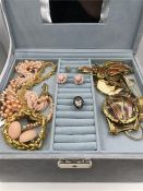 A large grey jewellery box containing a wide and varied collection of jewellery.