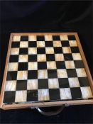 An African boxed with handle Chess set of Marble surfaced playing b oard and soapstone 32 playing