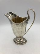 A Victorian hallmarked silver milk jug, makers mark EB