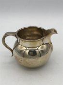 A silver milk jug, hallmarked Birmingham