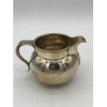 A silver milk jug, hallmarked Birmingham