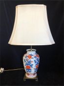 A Lamp base with Imari collars on a brass base and cream shade.