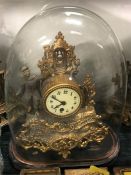 A Gilt clock under a glass dome