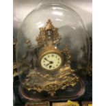 A Gilt clock under a glass dome