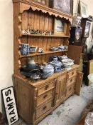 A Pine dresser with two shelves, six drawers, middle cupboard.