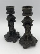 A Pair of Bronze cherub decorated candlesticks