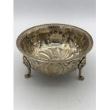 A silver three legged dish on claw feet