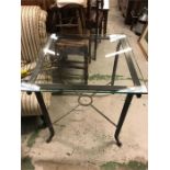 A Square wrought iron glass topped table