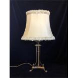 A brass table lamp on three feet