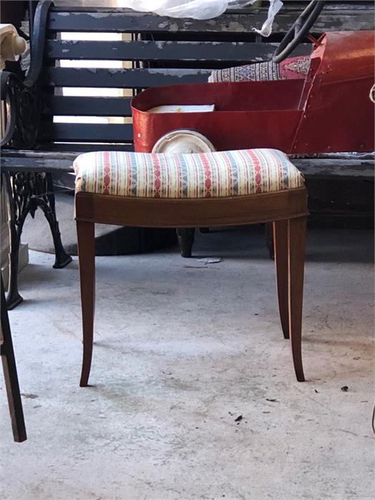 An upholstered dressing table stool