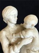 A figure of a woman holding a baby AF