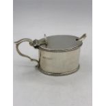 A silver mustard pot with glass liner