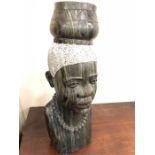 A marble or soapstone carved African head, of a lady carrying a pot on her head wearing a necklace