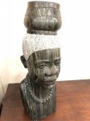 A marble or soapstone carved African head, of a lady carrying a pot on her head wearing a necklace