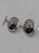 A Pair of Silver and Enamel cufflinks depicting ships at sail.