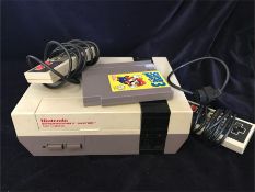 A Nintendo Entertainment System with two controllers and a Super Mario 3 game along with ten others