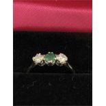 An 18ct yellow gold emerald and diamond three stone ring