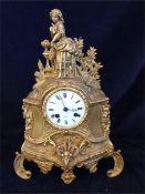 A gilt clock with figure with bird.